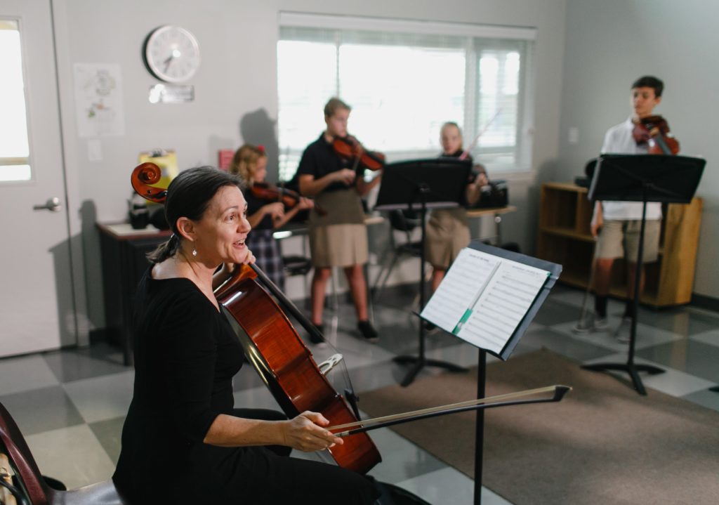 Classical music teacher with students and string instruments