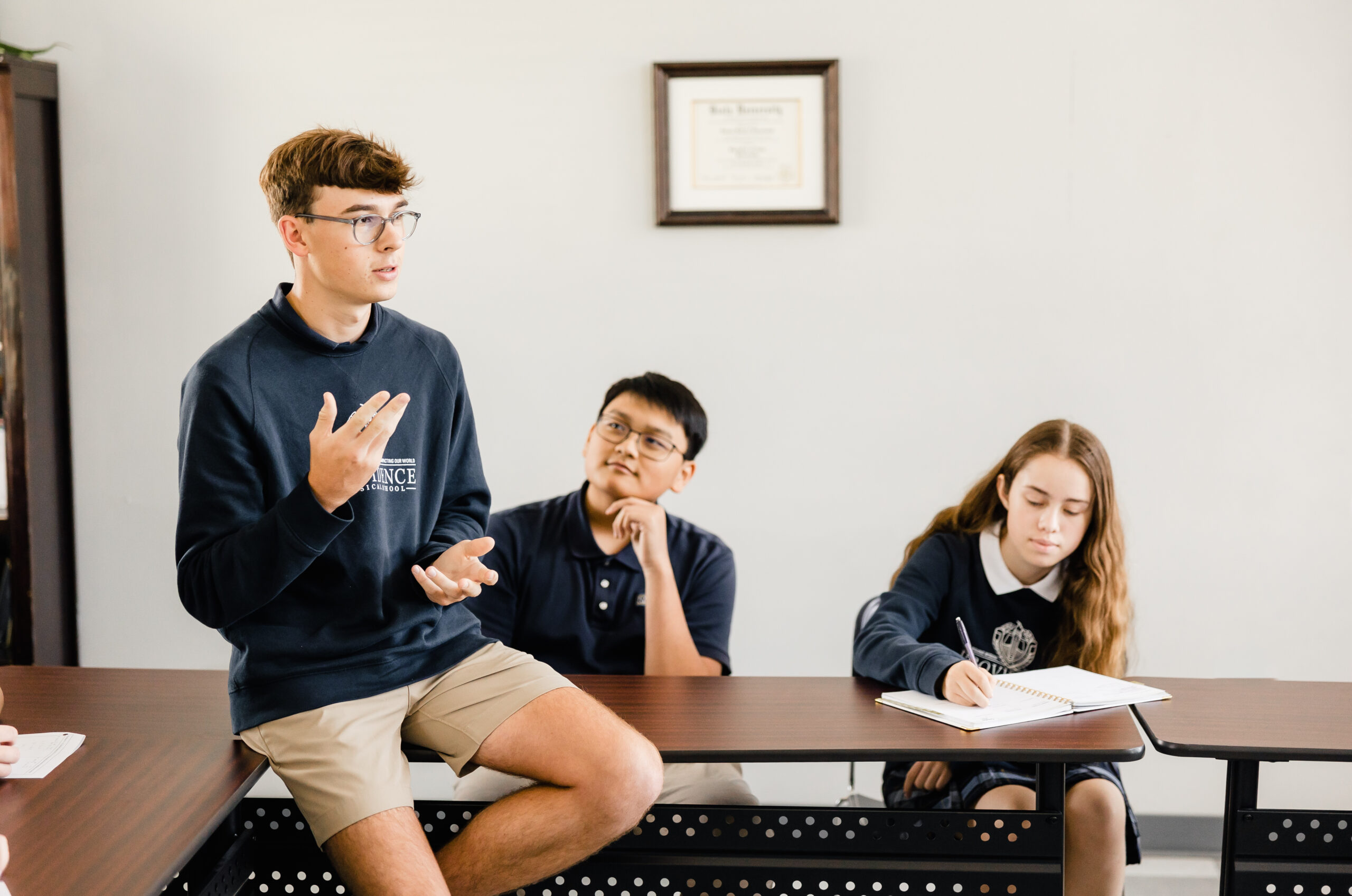 Student leads a discussion with classmates at Providence Classical School