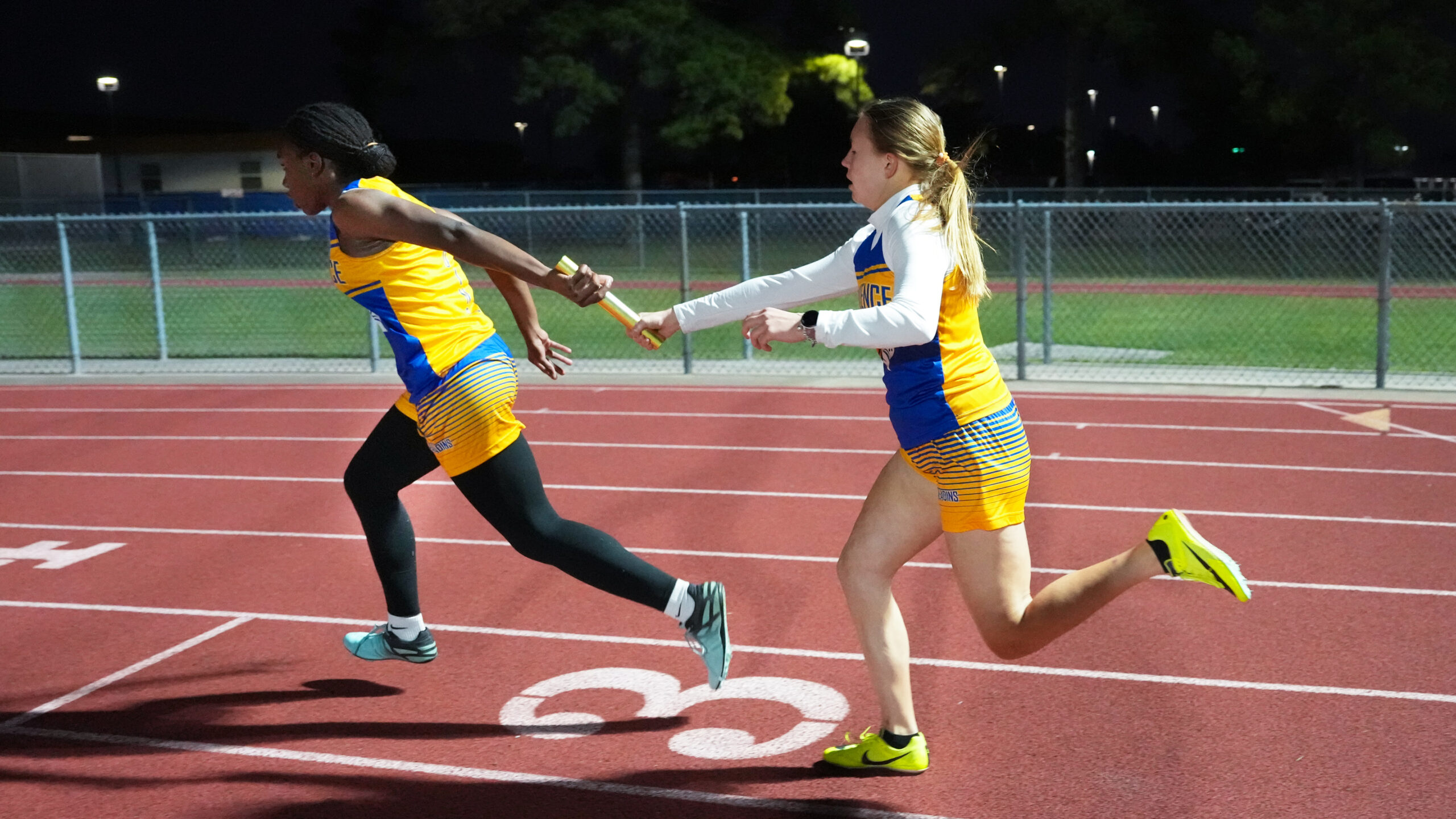Providence Classical School Middle School Track athletes handing off baton