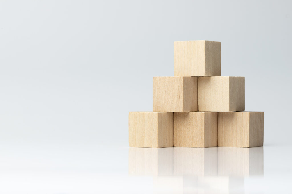 Six wooden blocks arranged in pyramid shape isolated on white background